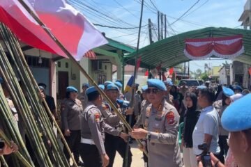 Personil Baret Biru Bidpropam Polda Kepri Bagikan Bendera Merah Putih di Kampung Tua Kampung Tengah Batubesar Nongsa