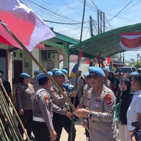 Personil Baret Biru Bidpropam Polda Kepri Bagikan Bendera Merah Putih di Kampung Tua Kampung Tengah Batubesar Nongsa